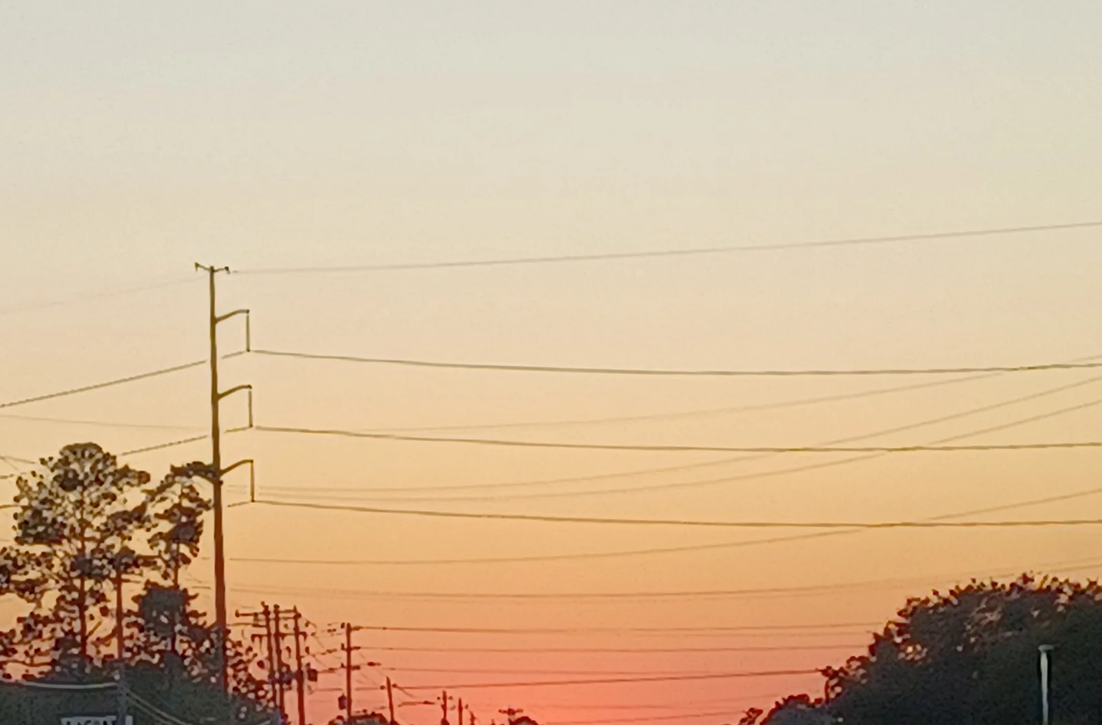 Power lines along a Wilmington road silhouetted against the sunset