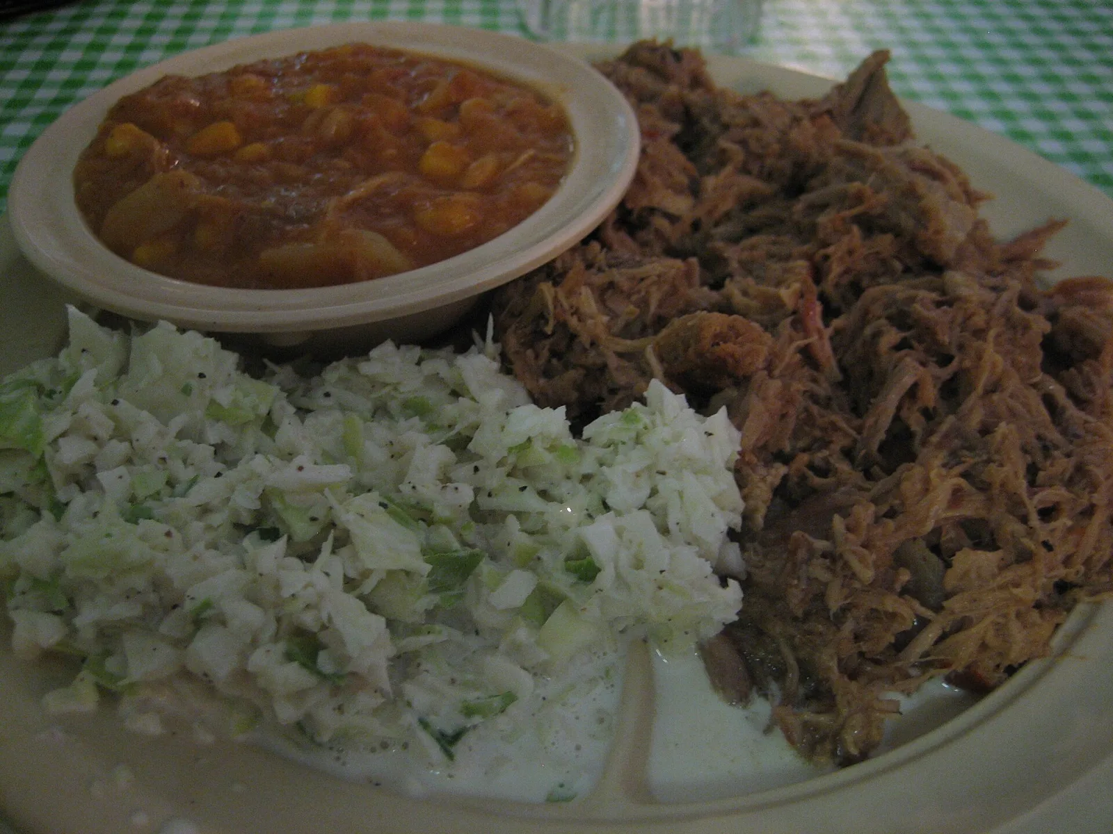 A plate of pulled pork barbecue with coleslaw and Brunswick stew. The photo was not taken at a Wilmington restaurant.
